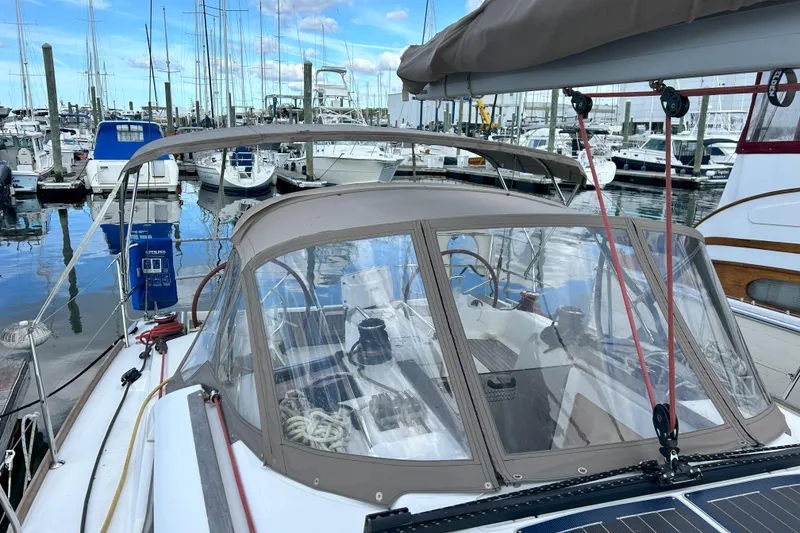 Slide: The Image of 2012 Jeanneau Sun Odyssey 379 sailboat docked in marina, featuring cockpit and canopy. - 2