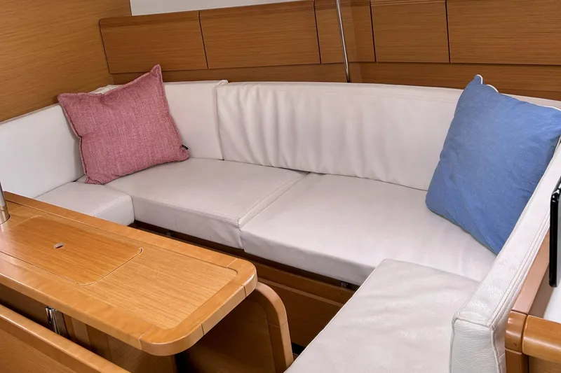 Slide: The Image of Interior of 2012 Jeanneau Sun Odyssey 379 with white cushions and colorful pillows. - 21