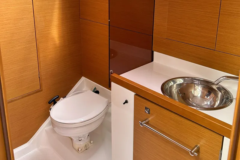 Slide: The Image of 2012 Jeanneau Sun Odyssey 379 yacht bathroom with wooden cabinetry and stainless steel sink. - 27