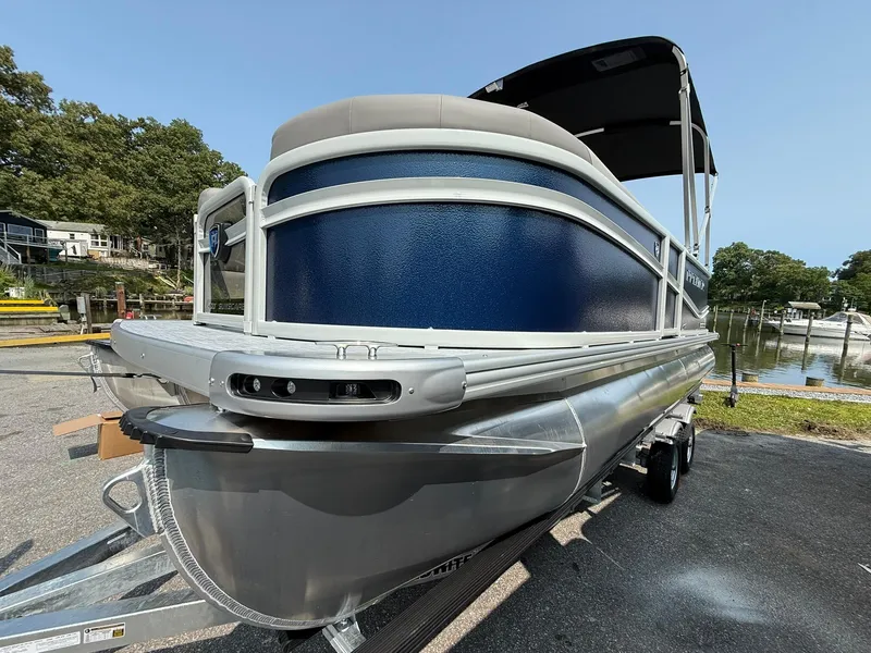 Slide: The Image of 2025 Premier 200 Sunscape RE XLC pontoon boat on trailer, blue and silver design. - 3