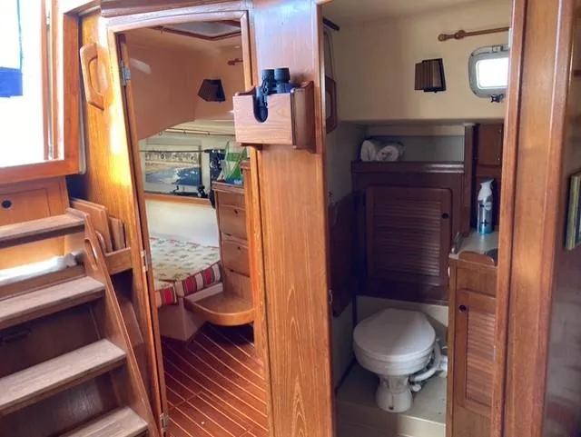Slide: The Image of Interior of 1987 Island Packet 38 sailboat, featuring wood finish, cabin, and bathroom. - 15
