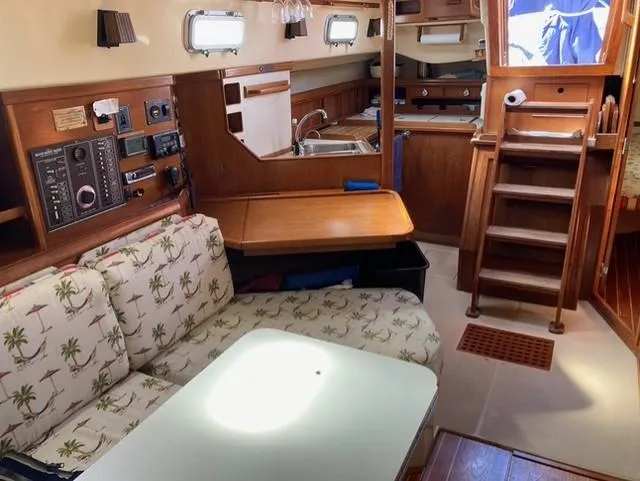 Slide: The Image of Interior of 1987 Island Packet 38 sailboat with cozy seating and wooden cabinetry. - 16