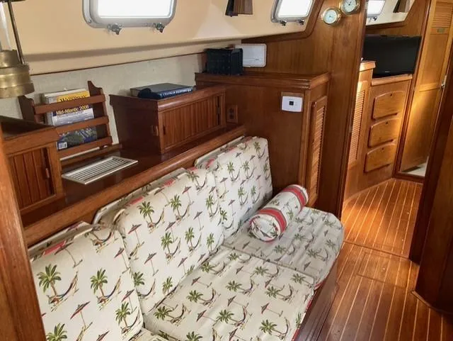 Slide: The Image of Interior of 1987 Island Packet 38 sailboat with tropical-themed cushions and wooden cabinetry. - 18