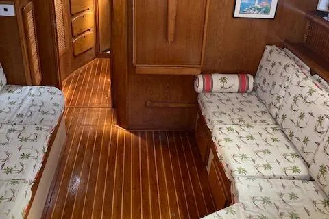 Slide: The Image of Interior of 1987 Island Packet 38 sailboat with wooden flooring and patterned seating. - 20