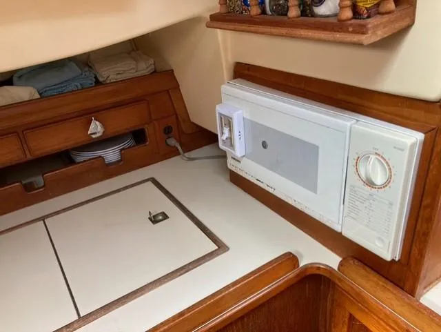 Slide: The Image of Interior of 1987 Island Packet 38 sailboat with wooden cabinetry and built-in appliances. - 25