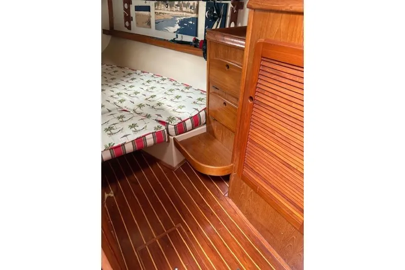 Slide: The Image of Interior of 1987 Island Packet 38 sailboat with wooden cabinetry and patterned bedding. - 29