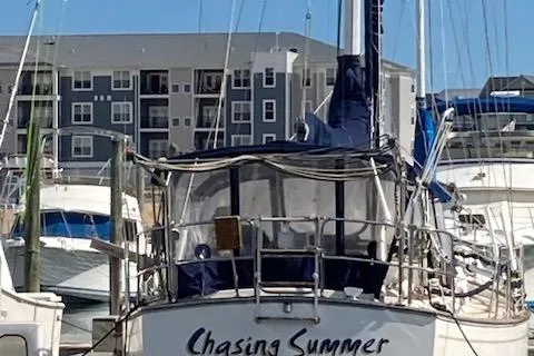 Slide: The Image of 1987 Island Packet 38 sailboat named "Chasing Summer" docked at a marina. - 3