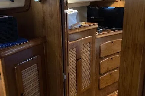 Slide: The Image of Interior of 1987 Island Packet 38 sailboat with wooden cabinetry and storage. - 31