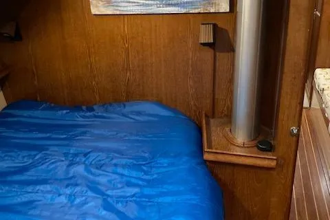 Slide: The Image of Cozy cabin interior of 1987 Island Packet 38 sailboat with blue bedding. - 32