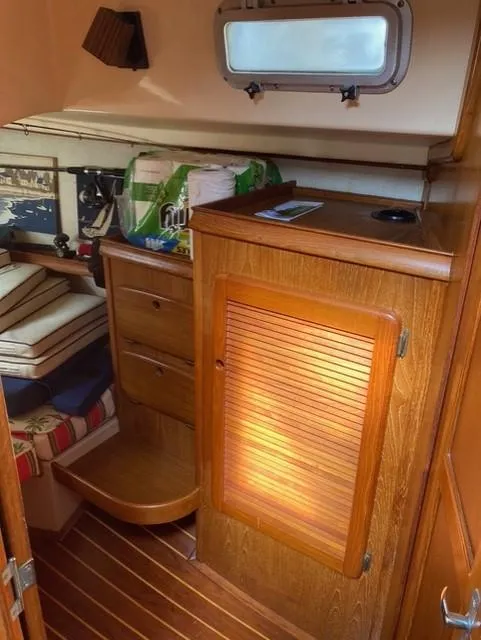 Slide: The Image of Interior of 1987 Island Packet 38 sailboat with wooden cabinetry and cozy seating area. - 33