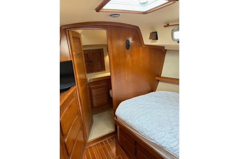Slide: The Image of 1987 Island Packet 38 interior cabin with wooden finish and cozy bed. - 34