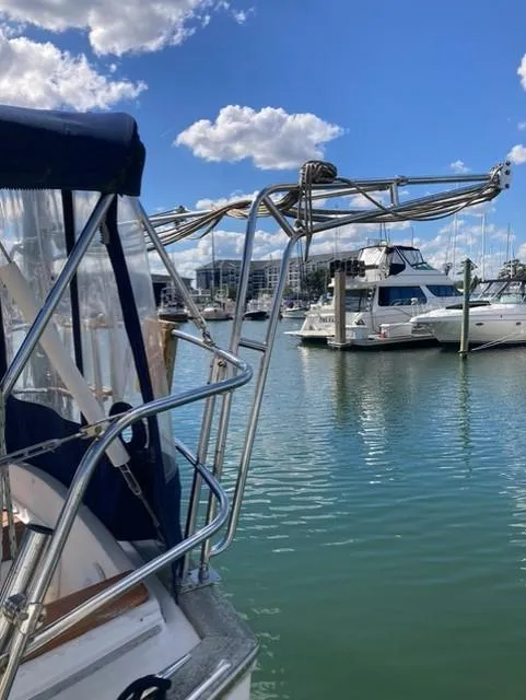 Slide: The Image of 1987 Island Packet 38 sailboat docked in marina under blue sky. - 4