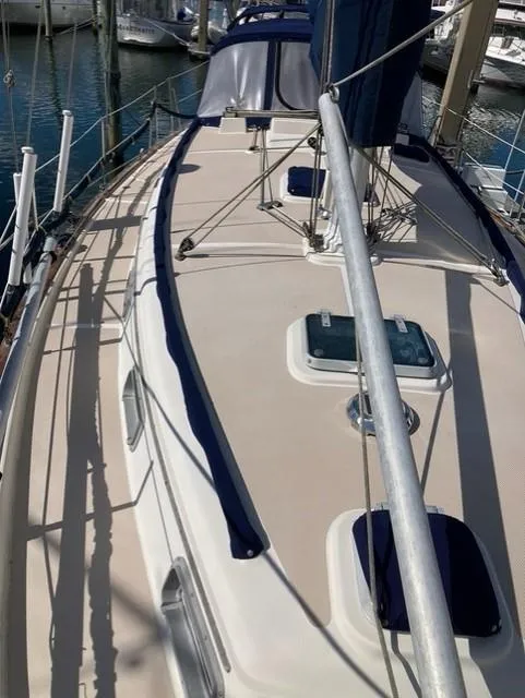 Slide: The Image of 1987 Island Packet 38 sailboat deck with blue trim, docked at marina. - 5