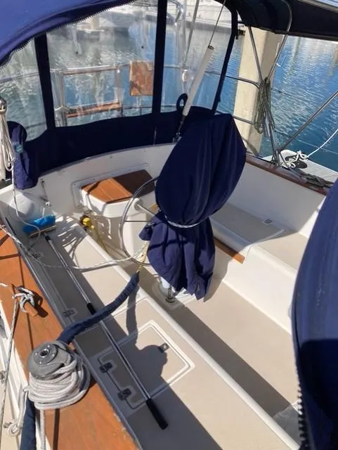 Slide: The Image of 1987 Island Packet 38 sailboat cockpit with blue canvas covers and wooden accents. - 7