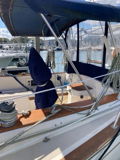 Slide: The Image of 1987 Island Packet 38 sailboat with blue canvas cover, docked at marina. - 8