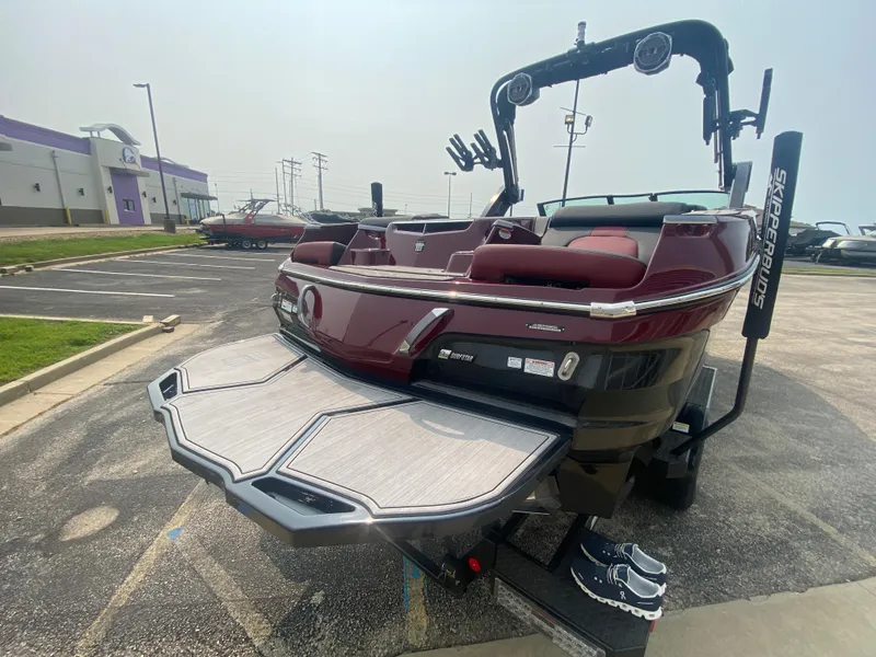 Slide: The Image of 2022 MasterCraft X24 boat with swim platform in a parking lot. - 10