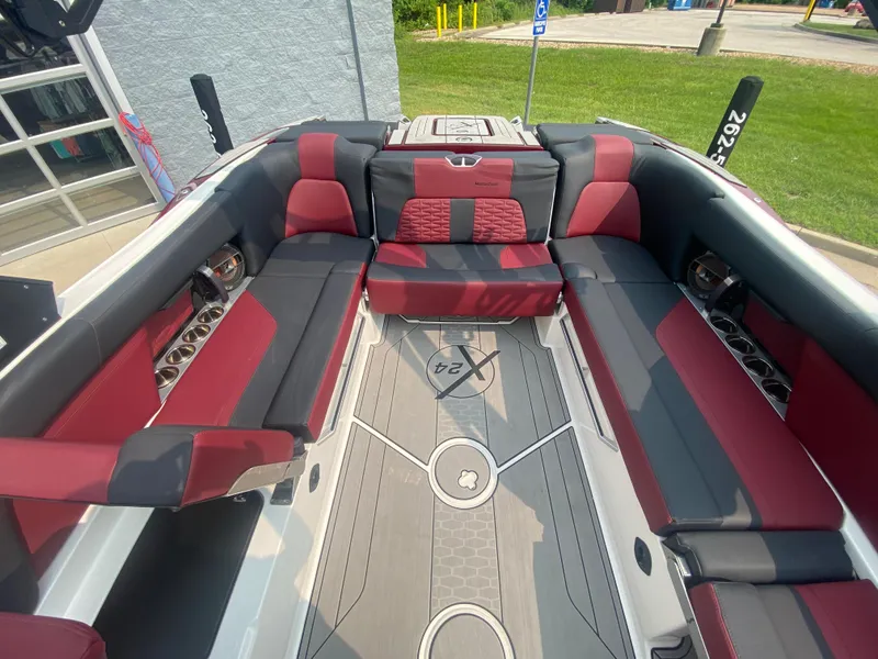 Slide: The Image of 2022 MasterCraft X24 boat interior with red and black seating, modern design, and spacious layout. - 14