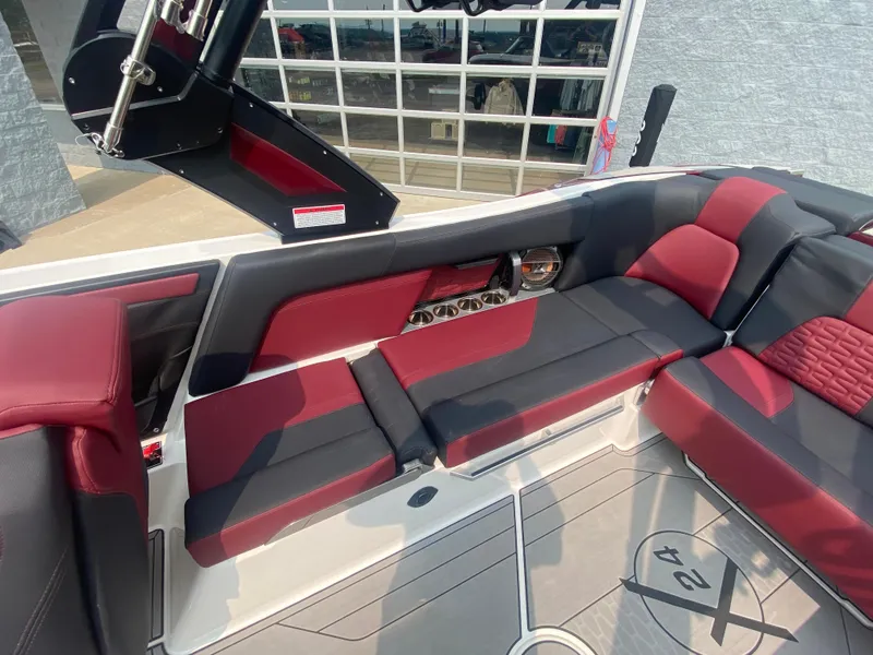 Slide: The Image of 2022 MasterCraft X24 boat interior with red and black seating, modern design. - 15