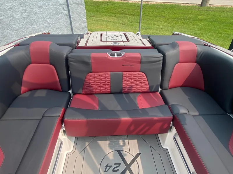 Slide: The Image of 2022 MasterCraft X24 boat interior with red and gray seating, showcasing luxury design. - 16