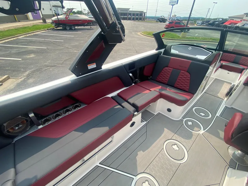 Slide: The Image of 2022 MasterCraft X24 boat interior with red and gray seating, open deck, and modern design. - 18