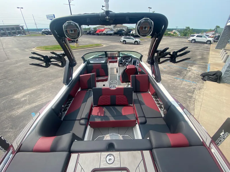 Slide: The Image of 2022 MasterCraft X24 boat interior with red and black seating, tower speakers, and wakeboard racks. - 20