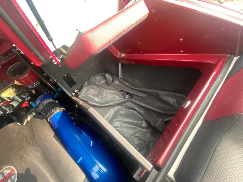 Slide: The Image of 2022 MasterCraft X24 interior storage compartment with red and black accents. - 24