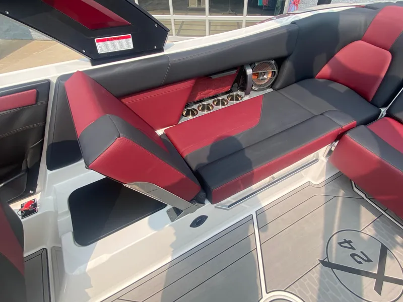 Slide: The Image of 2022 MasterCraft X24 boat interior with red and black seating and cup holders. - 26