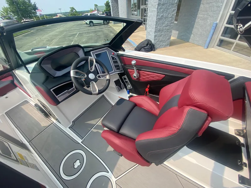 Slide: The Image of 2022 MasterCraft X24 boat interior with red and black seating, modern dashboard, and steering wheel. - 30
