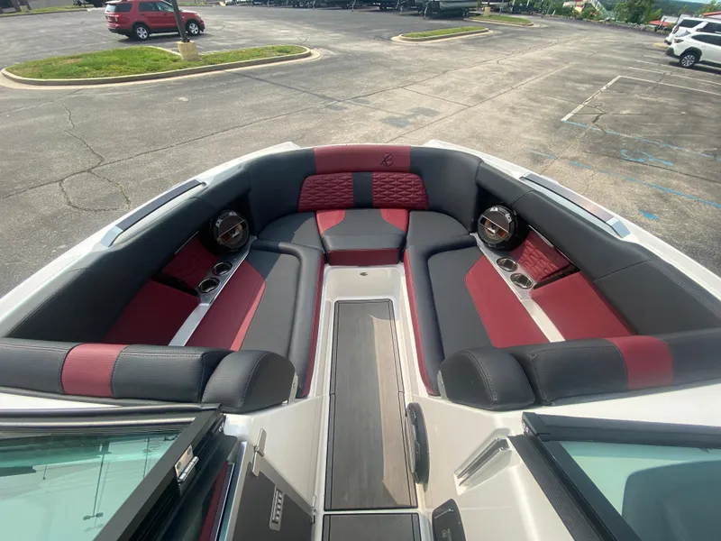 Slide: The Image of 2022 MasterCraft X24 boat interior with red and black seating in a parking lot. - 39