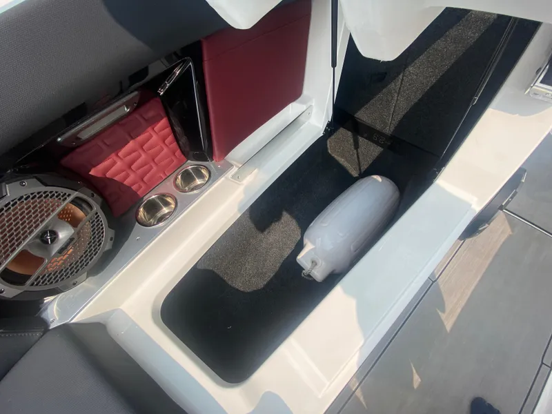 Slide: The Image of 2022 MasterCraft X24 interior with speaker, cup holders, and storage compartment. - 44