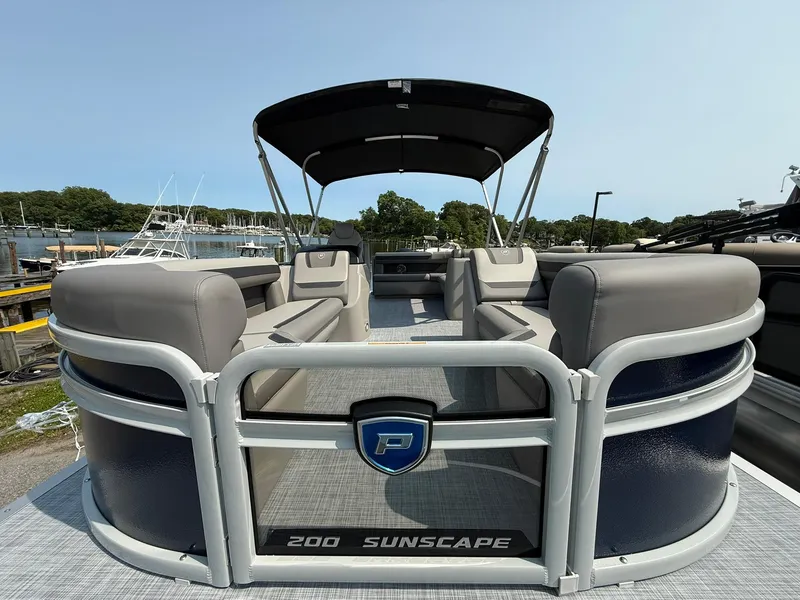 Slide: The Image of 2025 Premier 200 Sunscape RE XLC pontoon boat with spacious seating and canopy, docked at marina. - 4