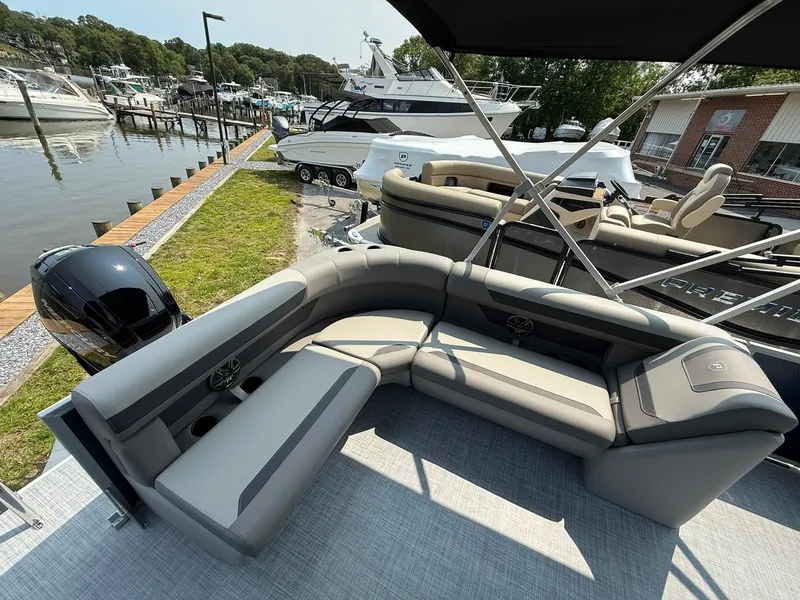 Slide: The Image of Premier 200 Sunscape RE XLC 2025 pontoon boat with luxurious seating by a marina. - 7