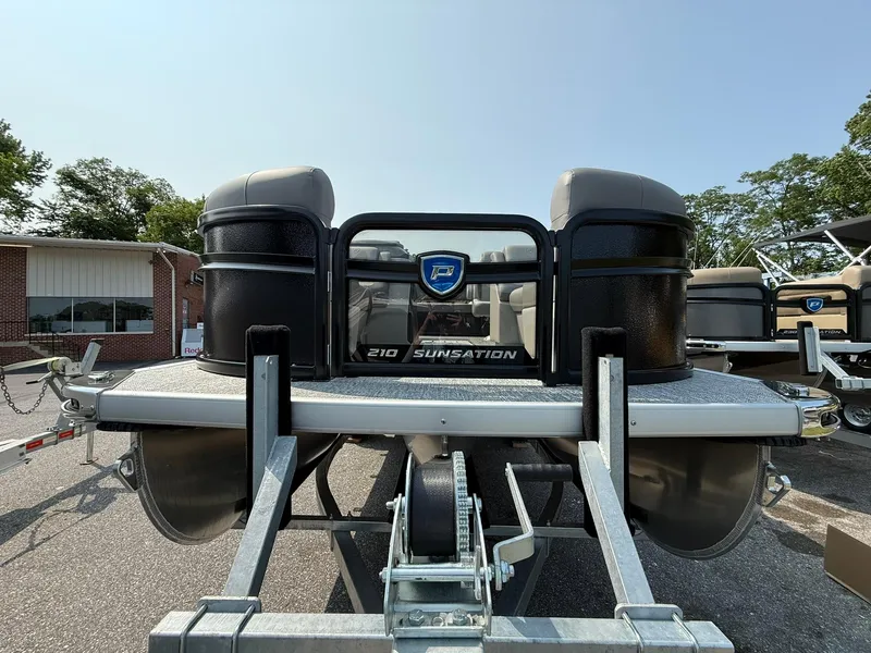 Slide: The Image of 2025 Premier 210 Sunsation RL pontoon boat interior with seating and console, docked outdoors. - 12