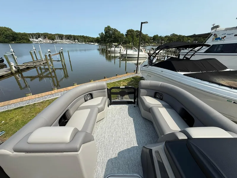 Slide: The Image of 2025 Premier 210 Sunsation RL pontoon boat on trailer, sleek black design. - 2