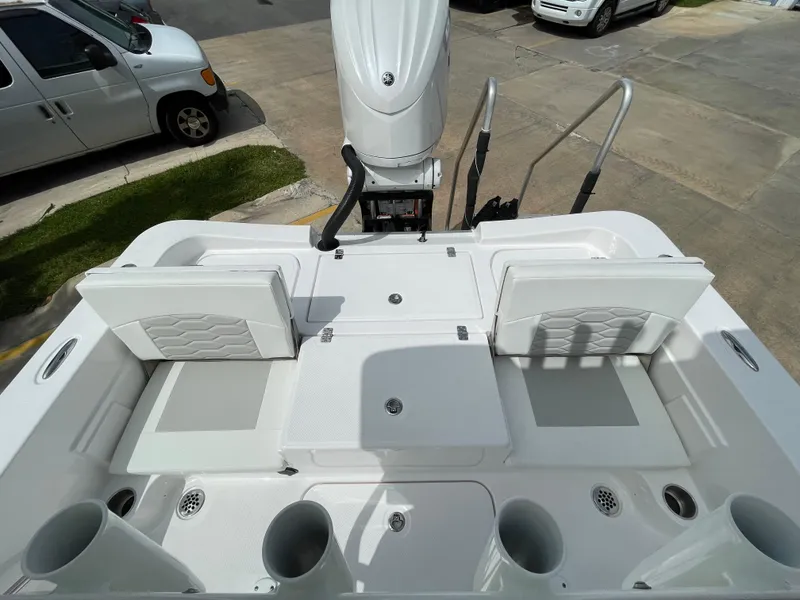 Slide: The Image of 2024 Aquasport 230 Pro Bay boat deck with seating and storage compartments. - 19