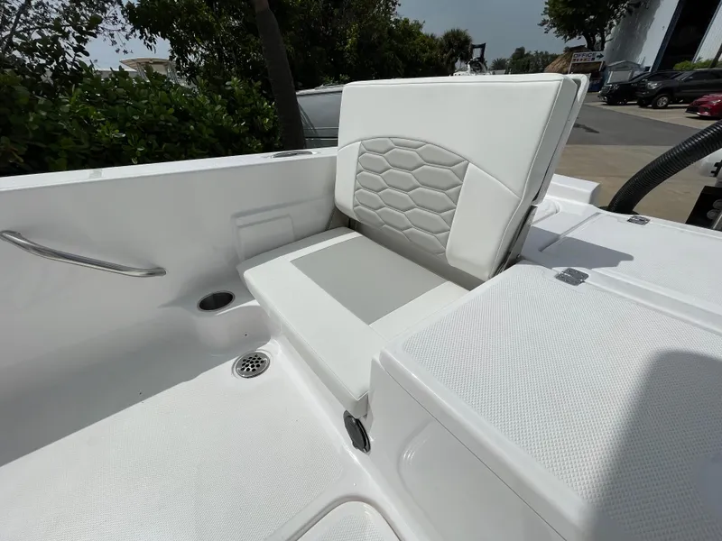 Slide: The Image of 2024 Aquasport 230 Pro Bay boat interior with white cushioned seating and modern design. - 20