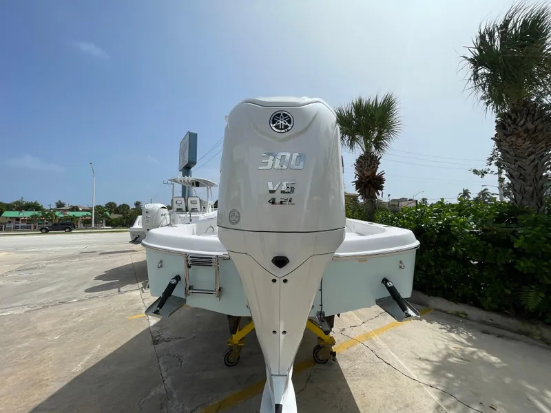 Slide: The Image of 2024 Aquasport 230 Pro Bay boat with powerful outboard motor, parked outdoors. - 23