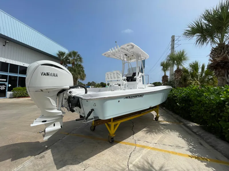 Slide: The Image of 2024 Aquasport 230 Pro Bay boat with Yamaha engine, displayed outdoors on a sunny day. - 24