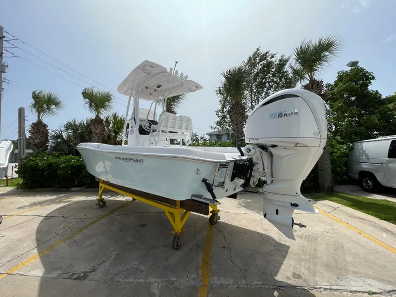 Slide: The Image of 2024 Aquasport 230 Pro Bay boat with Yamaha outboard, parked outdoors on a sunny day. - 25