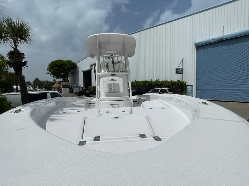 Slide: The Image of 2024 Aquasport 230 Pro Bay boat with T-top, docked near industrial building. - 28