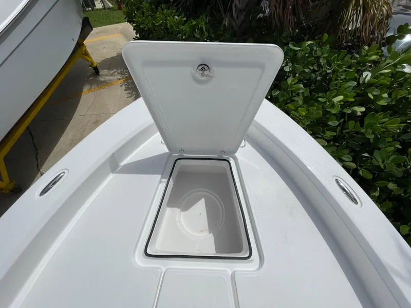 Slide: The Image of 2024 Aquasport 230 Pro Bay boat storage compartment open, showcasing interior space. - 6