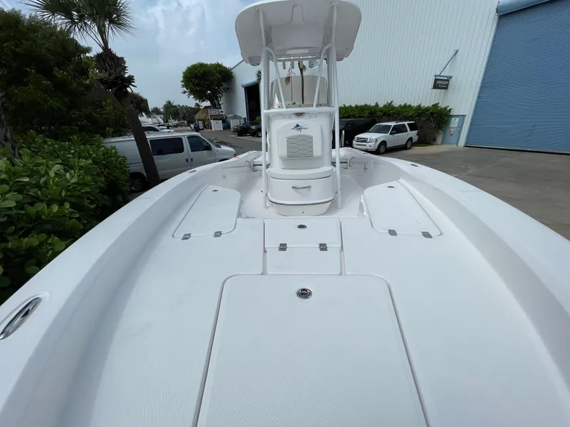 Slide: The Image of 2024 Aquasport 230 Pro Bay boat, white deck, docked near a warehouse. - 7