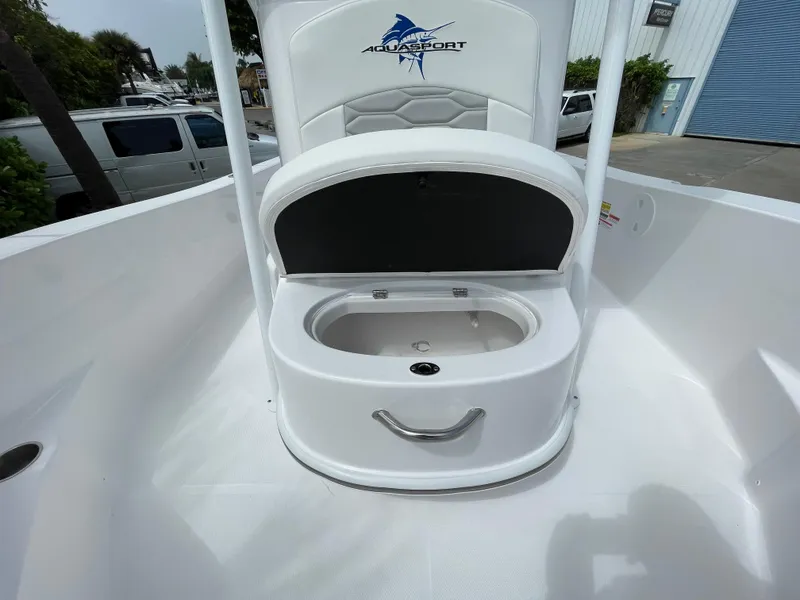 Slide: The Image of 2024 Aquasport 230 Pro Bay boat with open storage compartment on deck. - 9