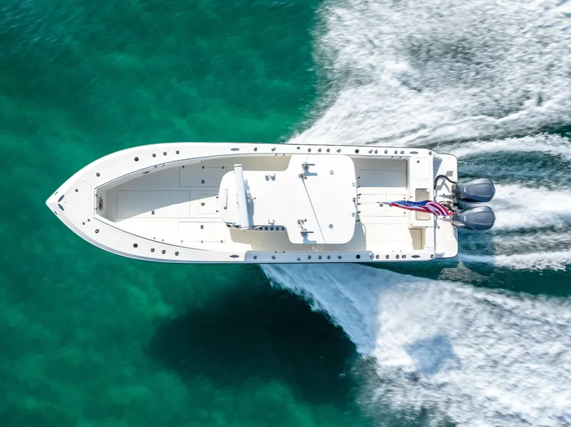 Slide: The Image of 2014 SeaVee 34 boat cruising on clear turquoise water, aerial view. - 11