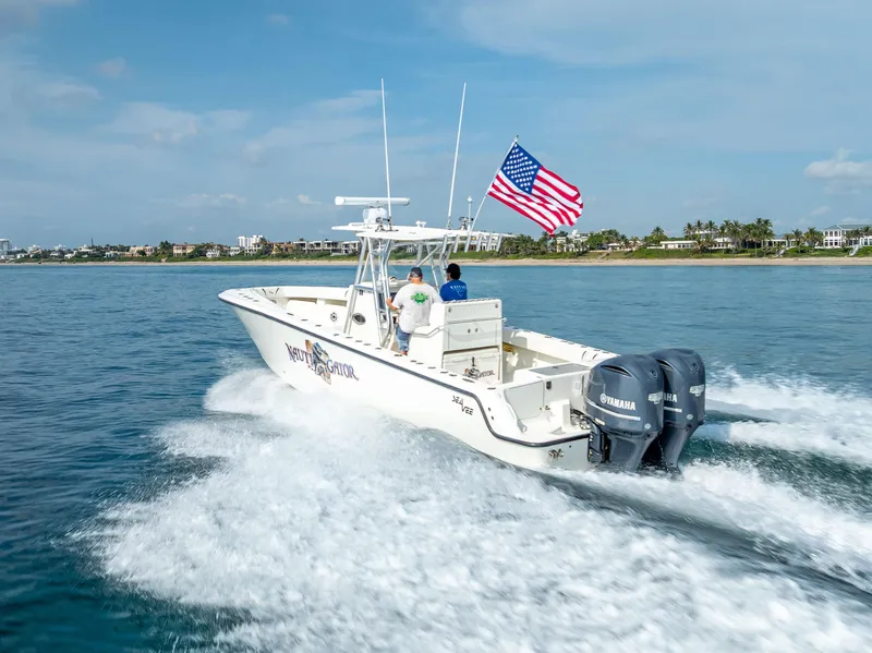 Slide: The Image of 2014 SeaVee 34 boat cruising with American flag, twin Yamaha engines, coastal background. - 13