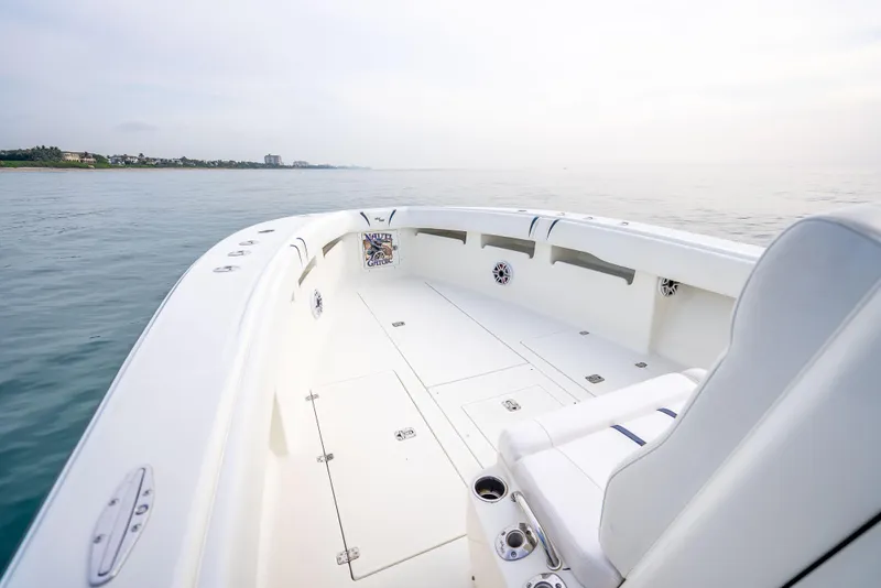 Slide: The Image of 2014 SeaVee 34 boat on calm water, featuring spacious deck and seating. - 21