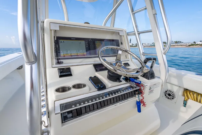 Slide: The Image of 2014 SeaVee 34 boat helm with steering wheel, navigation system, and ocean view. - 28