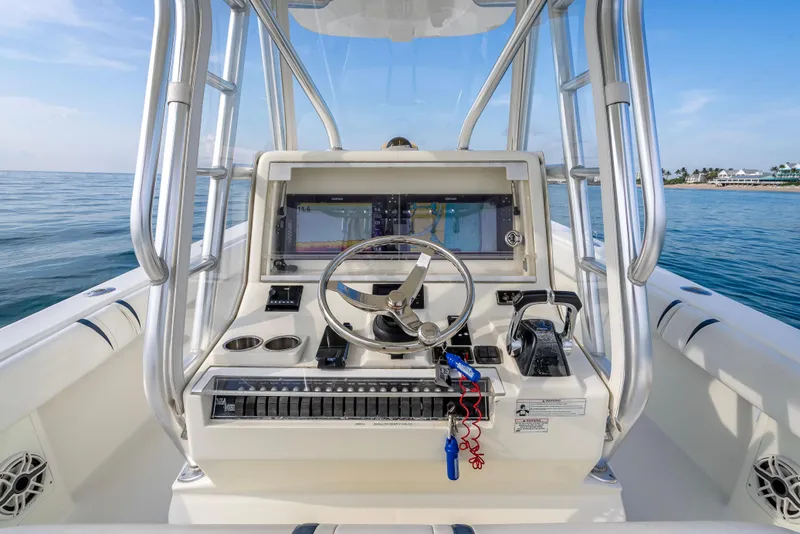 Slide: The Image of 2014 SeaVee 34 boat helm with steering wheel and navigation screens, ocean in background. - 29