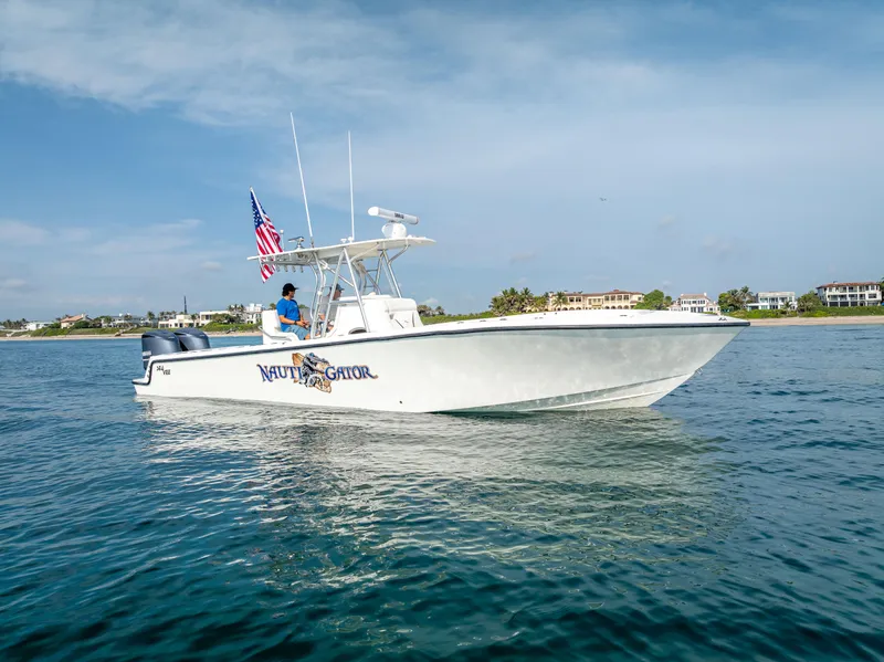 Slide: The Image of 2014 SeaVee 34 boat on water, American flag, clear sky, coastal background. - 4