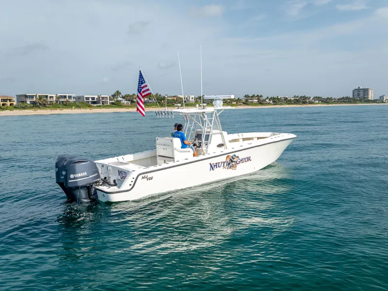 Slide: The Image of 2014 SeaVee 34 boat cruising on ocean, American flag, Yamaha engine, coastal background. - 5